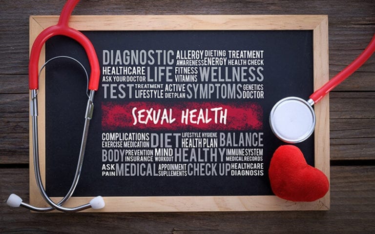 A small chalkboard on a wooden floor. A stethoscope and heart plushy frames a word cloud with words like Sexual Health, Diagnostic, Test, Medical, Check Up, Exercise, Balance, Allergy, etc.
