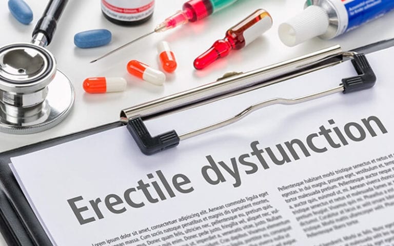 a clipboard with the title Erectile Dysfunction. Above the clipboard is a stethoscope, pills, syringes.